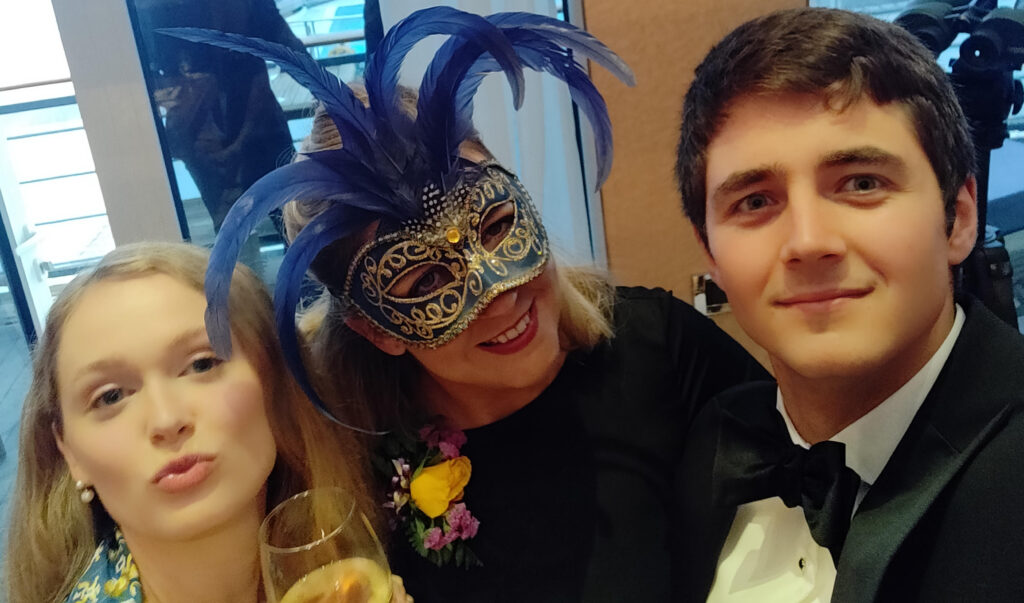 Bea in a masquerade mask at a party on the Queen Mary 2 transatlantic crossing with two other Alumni